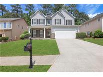Charming two-story home with a well-manicured lawn and a two-car garage at 3208 Juniper Nw Dr, Kennesaw, GA 30144