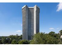 High-rise building with balconies in a residential area surrounded by lush greenery against a blue sky at 2660 Peachtree Rd # 7F, Atlanta, GA 30305
