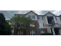Exterior view of a three story building with brick and beige siding and multiple windows at 14301 Waldrop Cv, Decatur, GA 30034