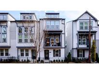 Modern townhome with white brick and gray siding, complemented by black window trim and wrought iron fence at 915 Katie Kerr Drive, Decatur, GA 30030
