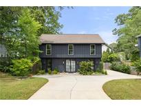 Modern two-story home with dark siding, large windows, well-manicured lawn and concrete driveway at 2824 Tupelo Se St, Atlanta, GA 30317