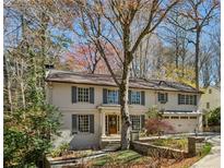 Charming two-story home with painted brick, shutters, and mature trees at 4627 Angelo Ne Dr, Atlanta, GA 30319