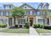 Charming townhome featuring brick and siding accents, complemented by mature landscaping and inviting entryway at 7725 Pierpoint Ln, Alpharetta, GA 30005