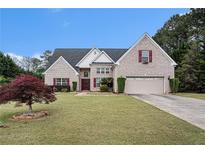 Charming brick home featuring a well-manicured lawn and attached two car garage at 25 Skylar Dr, Covington, GA 30016