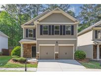 Charming two-story home with stone accents, a two-car garage, and a well-manicured front lawn at 506 Tallapoosa Trl, Woodstock, GA 30188