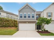 Charming two-story townhome with a two-car garage and professionally landscaped front yard at 302 Braswell Ct, Woodstock, GA 30188