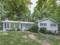 Charming home featuring blue shutters and a mature landscape offering shade and curb appeal at 712 Copper Trace Way, Woodstock, GA 30189