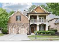 Charming two-story brick home with a stone accent, inviting front porch, manicured landscaping, and a two-car garage at 2652 Brickell Sq, Atlanta, GA 30341