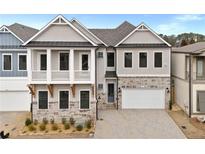 Beautiful two-story home featuring stone accents, a two-car garage, and a charming second-story balcony at 91 Batten Board Way, Woodstock, GA 30189