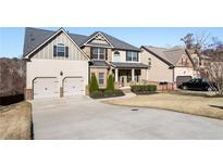 Charming two-story home with a manicured lawn, a long driveway, and a two-car garage at 6280 Stillwood Ln, Cumming, GA 30041