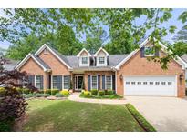 Charming brick home with a well-manicured lawn, black shutters, and attached two-car garage at 3151 Amesbury Way, Duluth, GA 30096