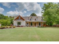 Charming two-story home featuring a landscaped yard and inviting front porch with wood columns at 1142 Wiley Bridge Rd, Woodstock, GA 30188