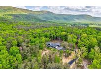 Stunning aerial view of a home nestled in lush greenery with a mountain backdrop at 555 E Valley Ne Rd, Rydal, GA 30171