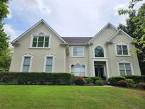 Elegant two-story home featuring a well-manicured lawn and symmetrical window placement at 365 Autumn Breeze Dr, Roswell, GA 30075