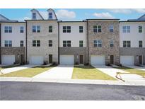 View of new townhome featuring an attached garage and modern brick and siding exterior at 4964 Villager Ln, Stone Mountain, GA 30083