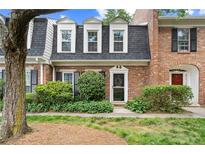 Charming brick townhome with well-maintained landscaping, black shutters, and a welcoming entrance at 5 Newport Nw Pl, Atlanta, GA 30318