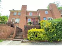 Brick condo building featuring multiple stories, a well-maintained entrance, and lush surrounding greenery at 142 Davis Mill Ct, Lawrenceville, GA 30044