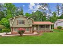 Charming home featuring mature trees, a well-maintained lawn and an inviting exterior at 3240 Corktree Trl, Stonecrest, GA 30038