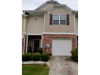 A charming townhouse with a brick facade, neutral siding, and a one-car garage at 2118 Burns View Ln, Lawrenceville, GA 30044