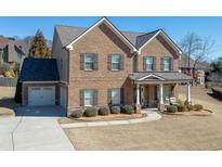 Charming two-story brick home with attached garage and a well-manicured front lawn at 2225 Independence Ln, Buford, GA 30519