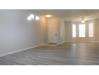 Spacious living room featuring sleek gray floors and a light-filled bay window at 162 Odyssey Turn, Conyers, GA 30012