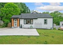 Charming home featuring a well-maintained lawn and a concrete driveway at 428 Tibbetts Se St, Marietta, GA 30060