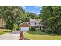 Charming two-story home with brick accents, a well-manicured lawn, and a spacious two car garage at 4524 Shumart Dr, Snellville, GA 30039