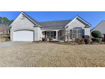 Charming single-story brick home with a two-car garage and manicured lawn at 609 Grand Ashbury Ln, Buford, GA 30518