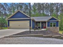 Charming blue craftsman-style home with a two-car garage and a well-manicured front yard at 154 Carmen Ln, Dallas, GA 30157