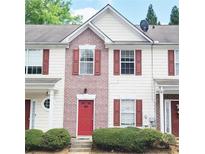 Charming townhouse with red door, shutters, brick facade and manicured landscaping at 3216 Panthers Trce, Decatur, GA 30034