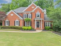 Charming two-story red brick home boasts a manicured lawn and lush landscaping at 3722 Somerset Nw Rdg, Kennesaw, GA 30144