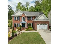 Beautiful two-story brick home with a manicured lawn and an attached two-car garage at 1657 Millhouse Lndg, Marietta, GA 30066