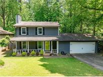 Charming two-story home with a welcoming front porch and well-manicured lawn provides great curb appeal at 555 Creekwood Xing, Roswell, GA 30076