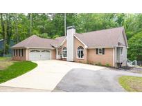 Charming brick home featuring an attached garage and well-maintained landscaping at 320 Williamsburg Cir, Mcdonough, GA 30253