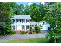 Inviting two-story home with a classic white facade, black shutters, and a meticulously maintained front yard at 3605 Sewell Mill Rd, Marietta, GA 30062