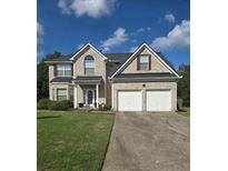 Charming two-story brick home with a two-car garage and well-manicured lawn at 5130 Hopewell Manor Dr, Cumming, GA 30028