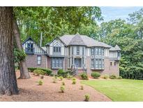 Charming Tudor-style home with beautiful brickwork and lush landscaping in a wooded setting at 5460 Lichenhearth Ct, Stone Mountain, GA 30087