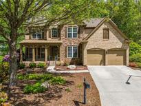 Charming two-story home boasts a stone and brick facade, two car garage and a beautifully landscaped front yard at 121 Brendylynn Trce, Woodstock, GA 30188