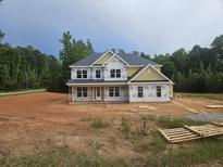 Two-story home featuring double paned windows and yellow siding in a partially wooded area at 3301 Lions Ruby Ln, Atlanta, GA 30349