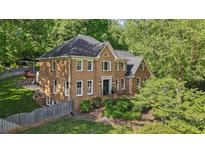 Charming two-story brick home with a well-manicured front yard and mature trees at 1880 Redbourne Dr, Atlanta, GA 30350