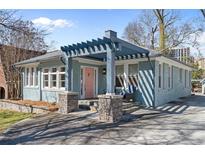 Charming blue home featuring a unique pergola over the front porch and a pink front door at 28 Peachtree Hills Ne Ave, Atlanta, GA 30305