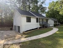 Charming home featuring fresh white siding, black roof, a convenient garage, and inviting curb appeal at 600 Mary Erna Dr, Fairburn, GA 30213