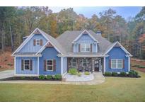 Charming blue two-story home with wooden shutters and a professionally landscaped yard at 401 Night Hawk Ct, Canton, GA 30114