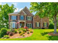 Beautiful two-story brick home boasts lush landscaping, an inviting entrance, and a well-manicured lawn at 7048 Bennington Ln, Cumming, GA 30041