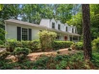Charming home with a covered porch, beautiful landscaping, and mature trees offering curb appeal at 1229 Colony Cir, Marietta, GA 30068