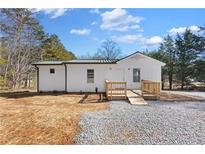Charming single-story home with white siding, green metal roof, and a ramp for easy access at 4064 Post Rd, Winston, GA 30187