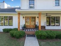Charming front entrance with wood columns, double glass doors, and manicured landscaping at 1435 Willis Lake Nw Dr, Kennesaw, GA 30152