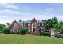 Traditional brick home with a manicured lawn and lush landscaping, exuding classic charm and curb appeal at 3331 Lockwood Sw Ct, Lilburn, GA 30047