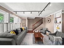 Inviting living room featuring a comfortable gray sofa, stylish decor, and a staircase leading to the upper level at 331 Lakemoore Ne Dr # C, Atlanta, GA 30342