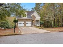 Charming two-story home featuring a stone facade, two-car garage, and well-maintained front yard at 100 Lantana Dr, Locust Grove, GA 30248
